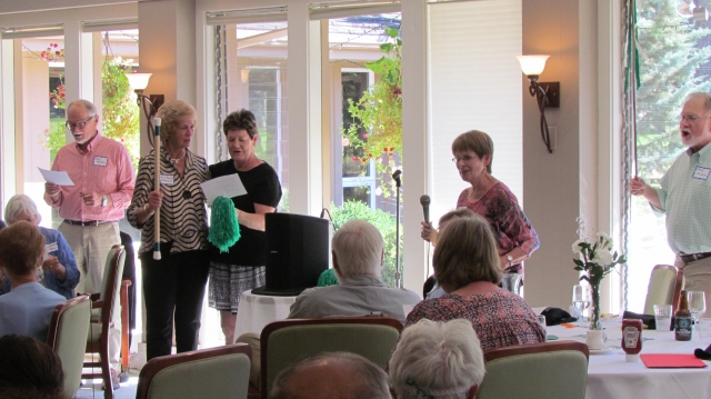 At the spirited urging of Karen Deyton Colleran (on the mic), MC Steve Johnson, Majorette Chris McEachron Hanson, Cheerleader Pat Templin Price, and Drum Major Sandy McCallum lead the CP Grads in singing the Clover Park Fight Song