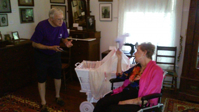 Davis and Judi Rembert inspecting the actual baby crib of Judi. She had donated crib to the Mathenson Museum