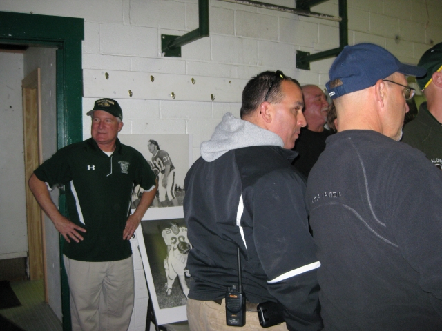 Greg Landis 72 (left) serves as the Rams Statistician. At right (sunglasses on his head) is CDHS Athletic Director John Confer.  Large posters in the background were brought by Steve Musser 73.