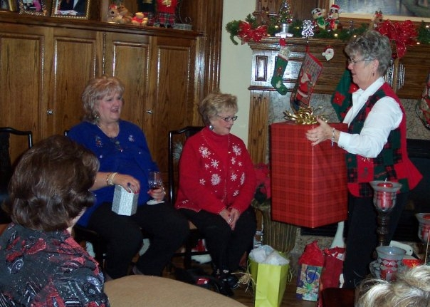 2009: Sue Beth getting a gift from Carolyn Walters. Also, Cindy Garris (red Sweater) and the back of Judy Riggs.