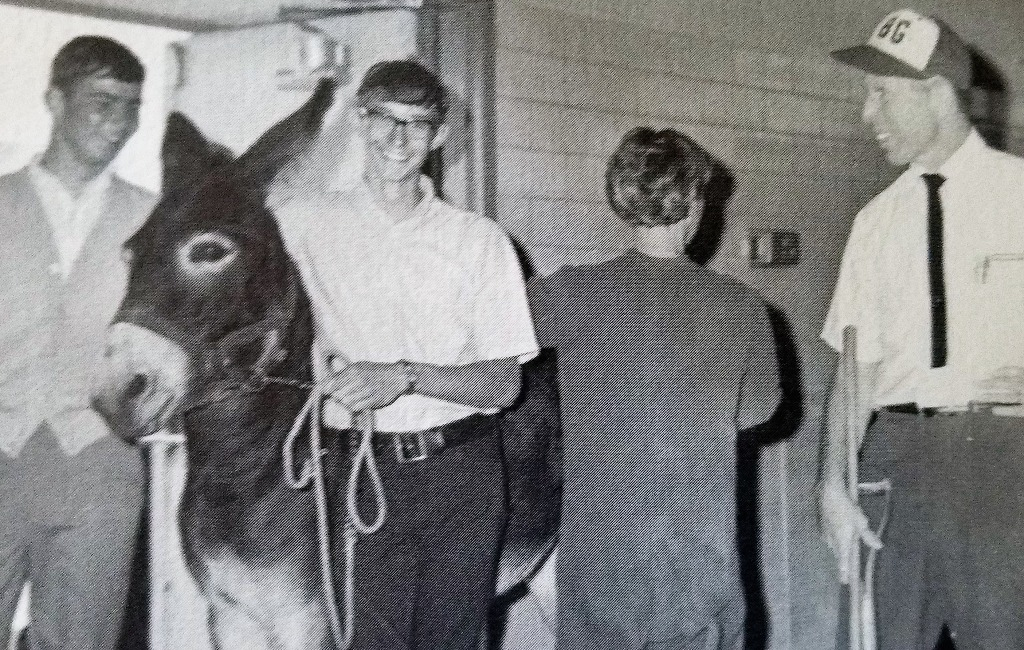 From 1968 Yearbook, Senior year.
(L-R): Rick Faulk, Byron Lee, and Bobby Bobcat Jane Nelson try to explain to chemistry teacher Mr. Earl Schaffer why a donkey was needed at the basketball game.
Mr. Schaffer sure looks upset!