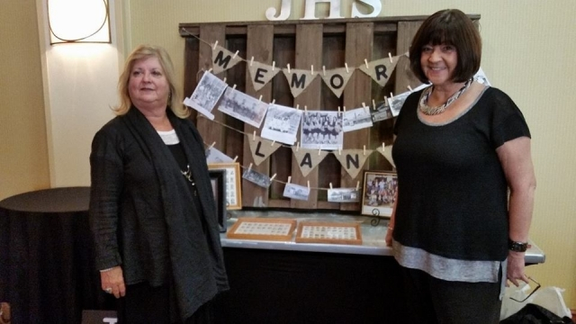 Betty Butler Roe and Margie Mays Lester at the Reunion Dinner standing in front of the Memory Lane Display