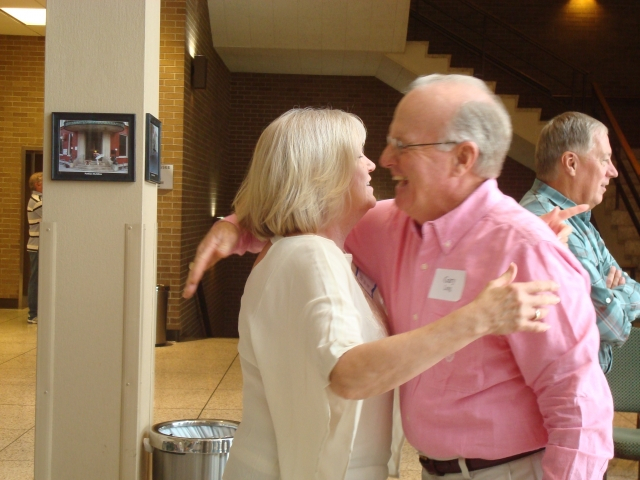 Ardis Wyatt Long and Gary Long greeting each other at the Brunch with Jimmy Hoppers in the background