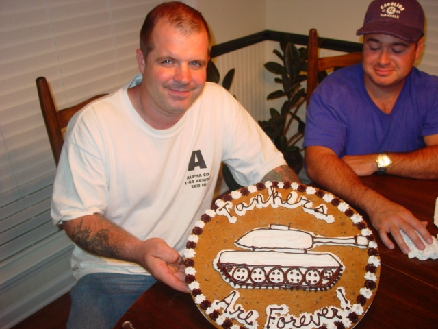 Me and one of my Dadâ€™s neighbors.  Iâ€™m holding a giant cookie they had made for me. It says, Tankers are Forever.