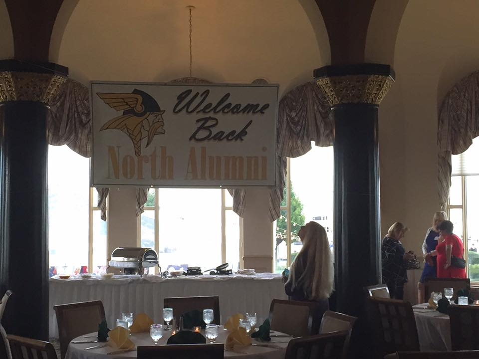 Carol Appleton Holloway looking at the Alumni Banner in our reception room at the Grosse Pointe Yacht Club. Background: Dawn Danielson Hill, Eva Bergstrand Sundevall, Sue Gallego Villegas