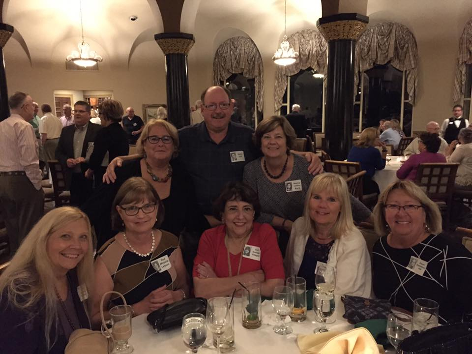 Front: Carol Appleton Holloway, Sue Moesta Letson, Sue Gallego Villegas, Eva Bergstrand Sundevall, Dawn Danielson Hill. Rear: Pam Killebrew Alessandro, Gary Hill, Nancy LeRoy Burk. Background upper left: Dennis Hock, Rick Pepper. At table upper right: Ju