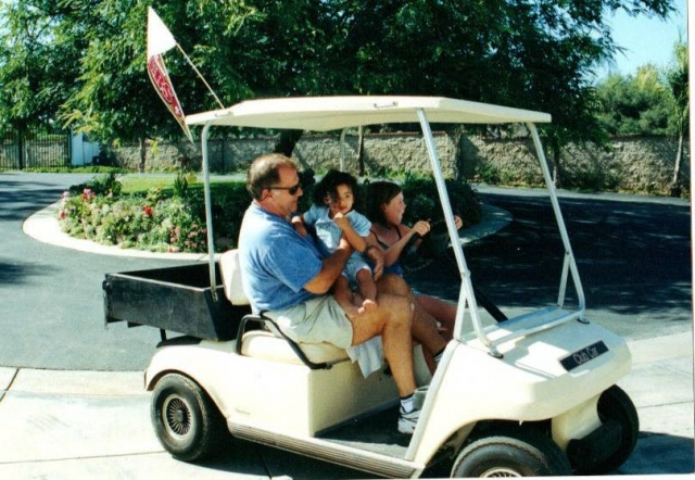 Ceg teaching grand daughter to drive golf cart.